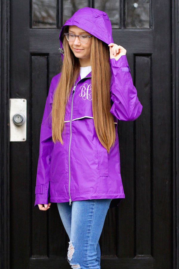 teenage girl standing in doorway wearing purple womens new englander raincoat with preppy monogram
