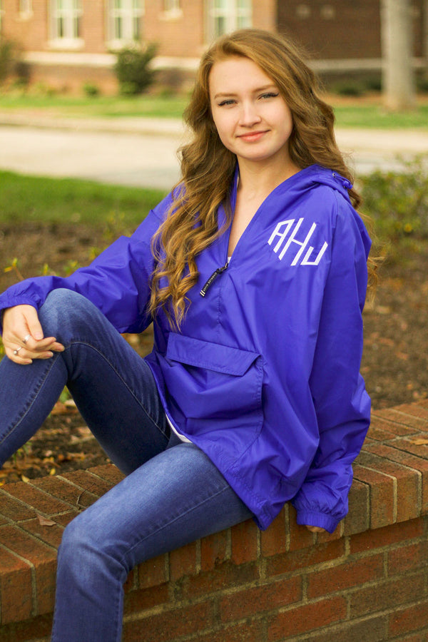 a woman sitting outside wearing royal blue charles river pullover with embroidered monogram